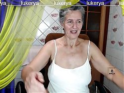Hot housewife Lukerya with a sweet smile flirts cheerfully on a webcam with fans in the kitchen online.